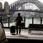 A man waits at a train platform as an outbreak of COVID-19 affects Sydney